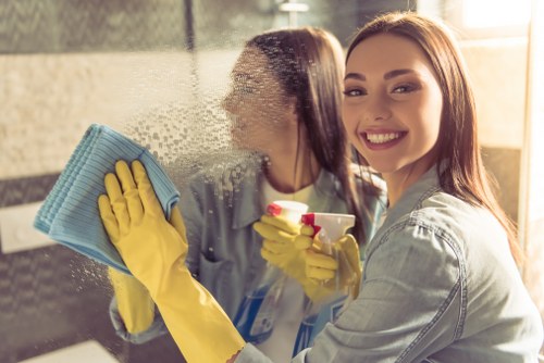 Domestic cleaner tidying a modern Surrey kitchen